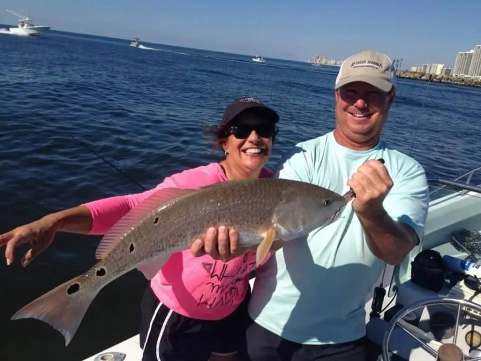 Anglers holding a redfish caught near Orange Beach